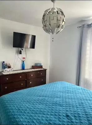a bedroom with a bed and a dresser and a television at Casa colinas del viento in Jacagua