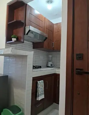 a kitchen with wooden cabinets and a stove top oven at Apartamento Las Carreras in Santo Domingo