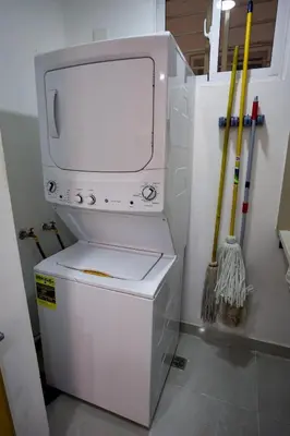 a white refrigerator with a dryer in a room at Amazing 2BR apartment near the airport in Los Frailes