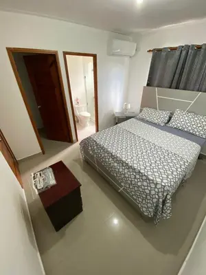a bedroom with a bed and a table in it at Beautiful apartment near STGO airport in Santiago de los Caballeros