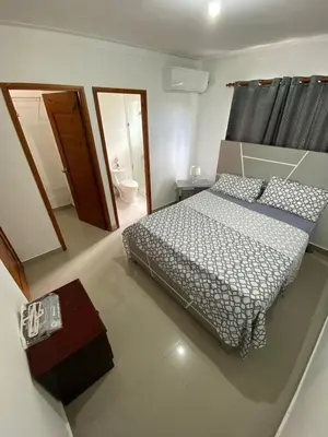 a bedroom with a bed and a bathroom at Beautiful apartment near STGO airport in Santiago de los Caballeros