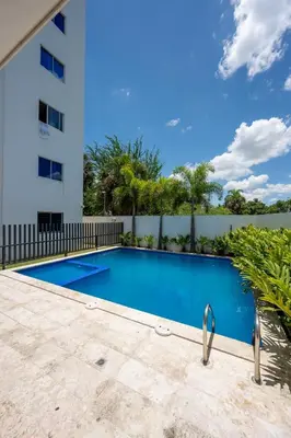 a swimming pool in front of a building at Luxurious Apartment with pool near airport in Santiago de los Caballeros