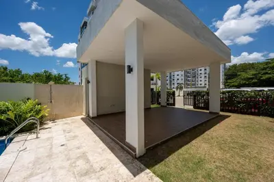 a patio with a fence and a building at Luxurious Apartment with pool near airport in Santiago de los Caballeros