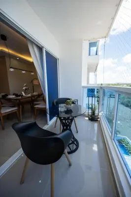 a living room with a table and chairs and windows at Luxurious Apartment with pool near airport in Santiago de los Caballeros