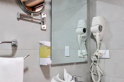 a bathroom with a mirror and a hair dryer at Comfy 1BR Centric Apt King Bed in Santo Domingo