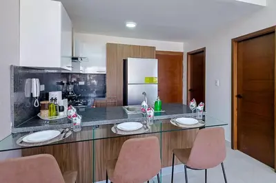 a kitchen with a counter with two chairs and a counter top at Comfy 1BR Centric Apt King Bed in Santo Domingo