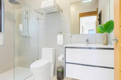 a bathroom with a toilet and a sink and a shower at Comfy 3BD Condo in Cocotal in Punta Cana