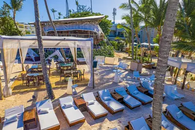 a beach with chairs and a tent and palm trees at Comfy 3BD Condo in Cocotal in Punta Cana