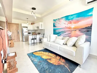 a living room with a white couch and a painting at Tropical Seaside Bliss DGM Resort at BocaChica in Boca Chica