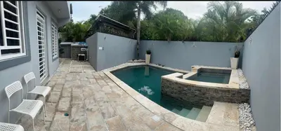 a swimming pool in the side of a house at Hermosa Casa familiar en las orquideas LR in La Romana