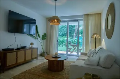 a living room with a couch and a tv at Escape Oasis in Playa Dorada Pool & Beach in Puerto Plata