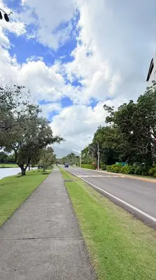 an empty street with a road next to a lake at Escape Oasis in Playa Dorada Pool & Beach in Puerto Plata