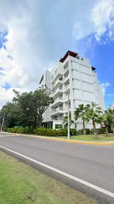 a large white building on the side of a road at Escape Oasis in Playa Dorada Pool & Beach in Puerto Plata