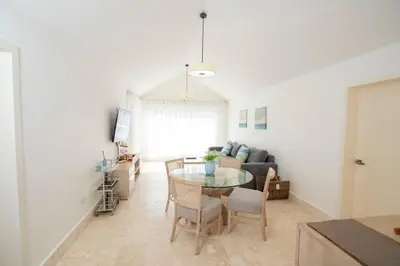 a living room with a table and a couch at Modern 2BR Caribbean Apt -Pool & Beach Access in Puerto Plata