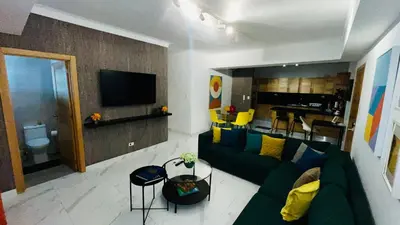 a living room with a green couch and a television at Apartamento tranquilo, céntrico y confortable in Santo Domingo