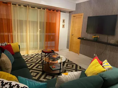 a living room with a couch and a flat screen tv at Apartamento tranquilo, céntrico y confortable in Santo Domingo