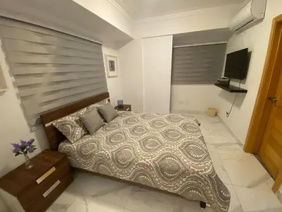 a bedroom with a large bed and a television at Apartamento tranquilo, céntrico y confortable in Santo Domingo