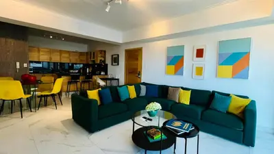 a living room with a blue couch and a table at Apartamento tranquilo, céntrico y confortable in Santo Domingo