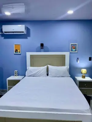 a blue bedroom with a large bed with a blue wall at Beach Days & City Nights! Centrally Near Everything in Santo Domingo