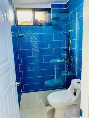 a blue tiled bathroom with a toilet and a sink at Beach Days & City Nights! Centrally Near Everything in Santo Domingo