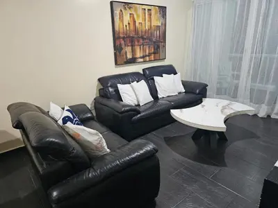 a living room with a black leather couch and a coffee table at Dreamvillage in Boca Chica