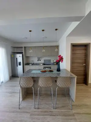 a kitchen with a table with chairs and a vase with flowers at La Stuga del Mar - Walk to Portillo Beach, Terrenas in Las Terrenas
