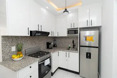 a kitchen with white cabinets and a stainless steel refrigerator at Cozy 1BR 1BA Bayahibe Getaway with Pool - Maravilla in San Rafael del Yuma