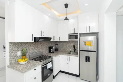 a kitchen with white cabinets and a stainless steel refrigerator at Cozy 1BR 1BA Bayahibe Getaway with Pool - Maravilla in San Rafael del Yuma