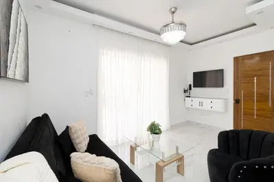 a living room with a black couch and a glass table at Cozy 1BR 1BA Bayahibe Getaway with Pool - Maravilla in San Rafael del Yuma