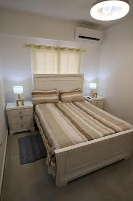 a bedroom with a large bed with two night stands at Amazing 2BR apartment near the airport in Los Frailes