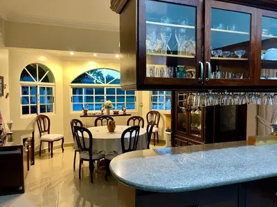 a kitchen with a table and a dining room with windows at Villa in Metro Country Club, Juan Dolio in Juan Dolio