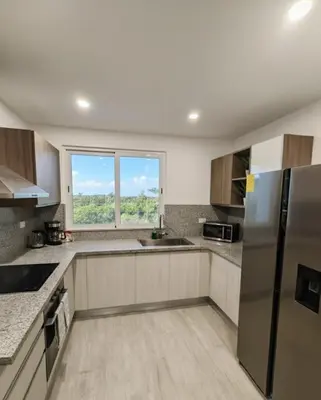 a kitchen with stainless steel appliances and a window at Apartamento de Lujo Punta Cana Hard Rock in Punta Cana