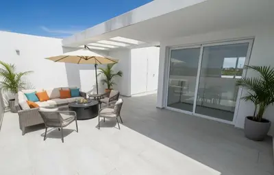 a patio with a couch and an umbrella at Apartamento de Lujo Punta Cana Hard Rock in Punta Cana
