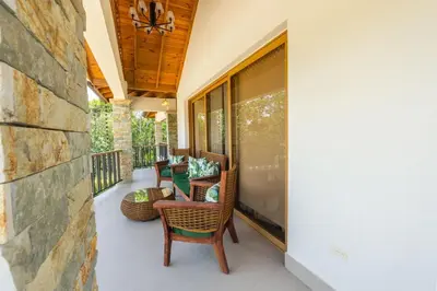 an outdoor patio with chairs and a stone wall at Villa Monaco RD in Concepción de La Vega