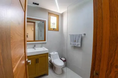 a bathroom with a toilet and a sink and a mirror at Villa Monaco RD in Concepción de La Vega