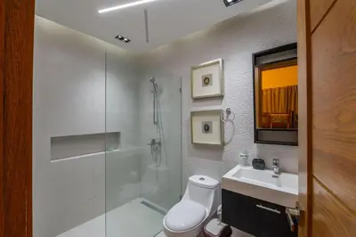 a bathroom with a shower and a toilet and a sink at Villa Monaco RD in Concepción de La Vega