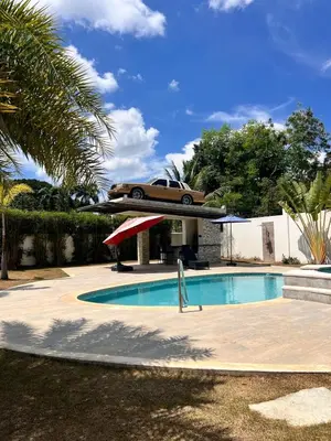a car is flying over a swimming pool at Villa Monaco RD in Concepción de La Vega