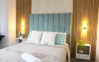 a bedroom with a large bed with a blue headboard at Casa Bonita con Jacuzzi in Los Mameyes