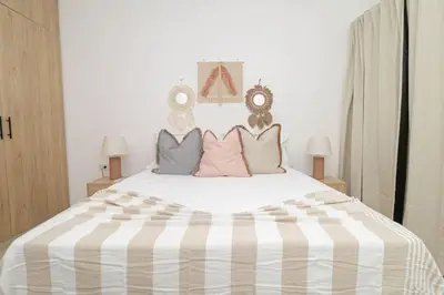 a bedroom with a large bed with pink and grey pillows at Sylish 2 Bed Retreat in Sunshine Bayahibe in San Rafael del Yuma