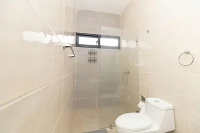 a white bathroom with a toilet and a shower at Sylish 2 Bed Retreat in Sunshine Bayahibe in San Rafael del Yuma