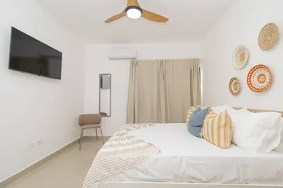 a white bedroom with a bed and a ceiling fan at Sylish 2 Bed Retreat in Sunshine Bayahibe in San Rafael del Yuma
