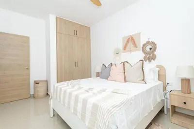 a white bedroom with a large white bed with pillows at Sylish 2 Bed Retreat in Sunshine Bayahibe in San Rafael del Yuma