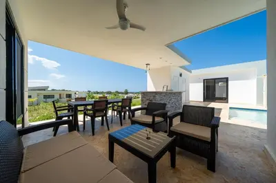 a living room with tables and chairs and a pool at Brand New Modern Caribbean Retreat 3BR in Sosúa