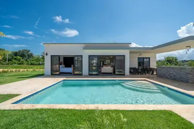 a villa with a swimming pool in front of a house at Brand New Modern Caribbean Retreat 3BR in Sosúa