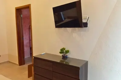 a living room with a dresser with a television on a wall at Villa Modena in Las Terrenas