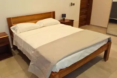 a bedroom with a large bed with white sheets at Villa Modena in Las Terrenas