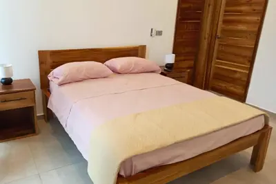 a bedroom with a bed with two pink pillows at Villa Modena in Las Terrenas