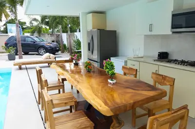 a kitchen with a wooden table and some chairs at Villa Modena in Las Terrenas
