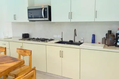 a kitchen with white cabinets and a stove top oven at Villa Modena in Las Terrenas