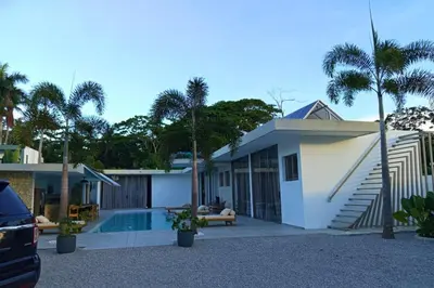 a house with a swimming pool and palm trees at Villa Modena in Las Terrenas